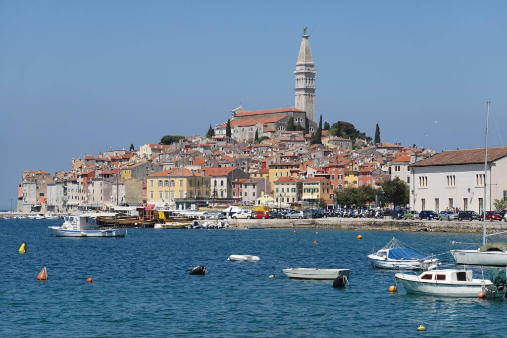 Panorama von Rovinj aus der Nähe mit kleinen Booten im Hafen.