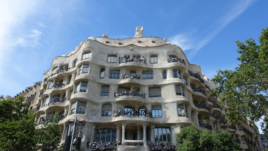 Haus mit unregelmäßig geschwungener Fassade und kunstvoll gestalteten Balkonen.